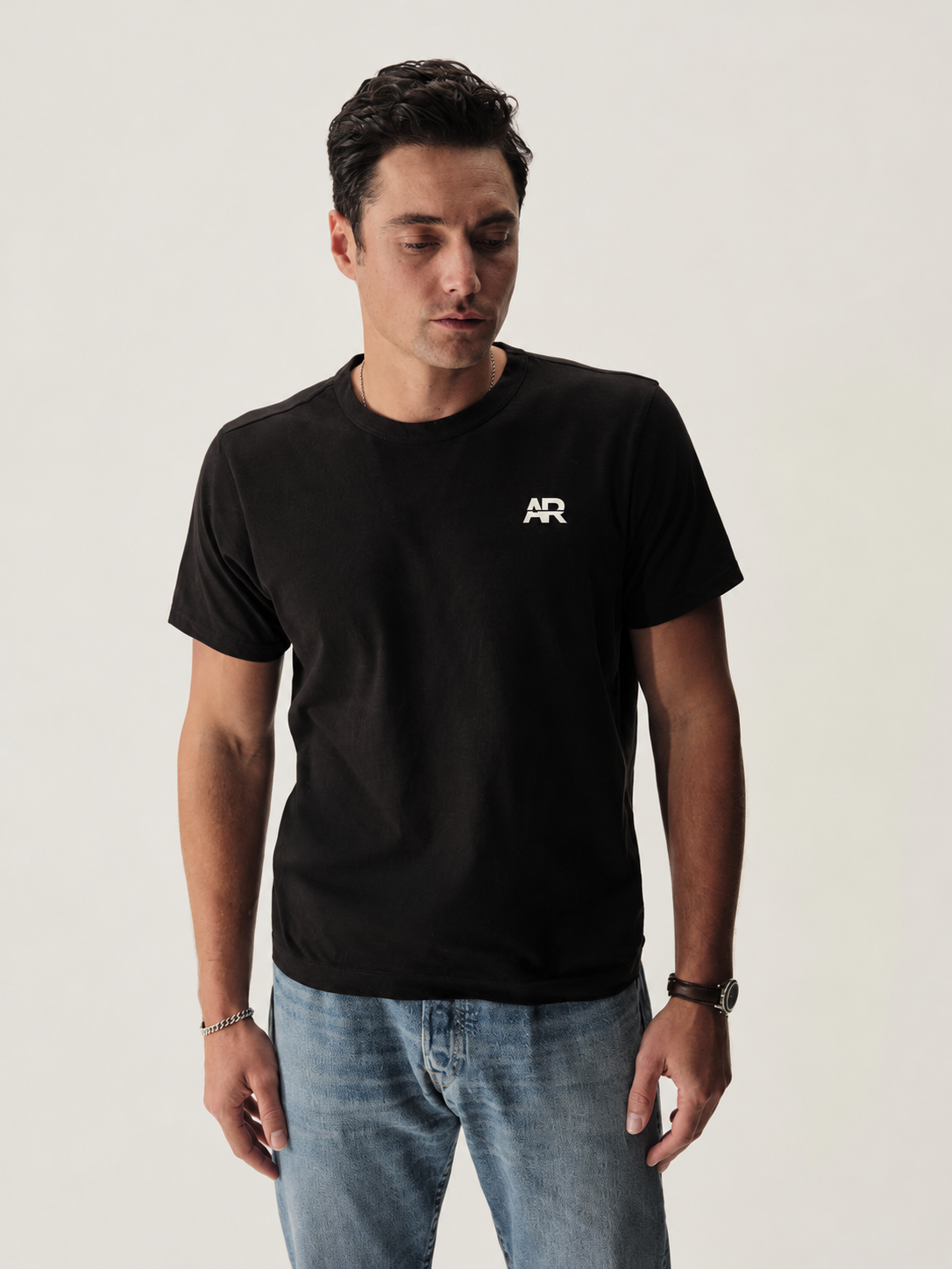 Model wearing the black Pima Classic Tee with a white AR chest logo
